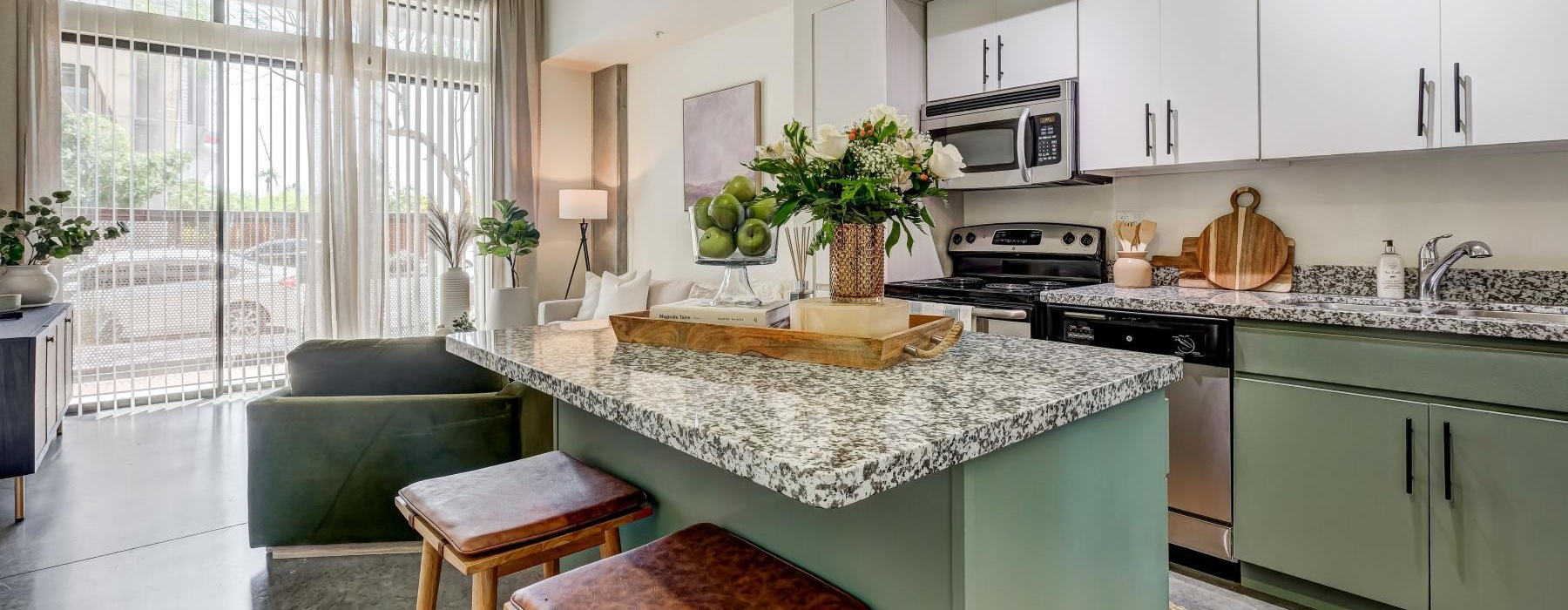 a kitchen with bar stools at island